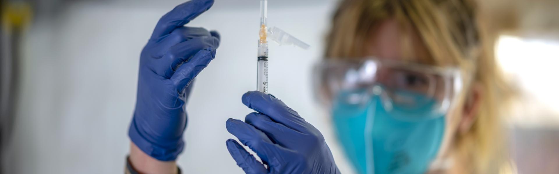 A nursing student is holding a syringe